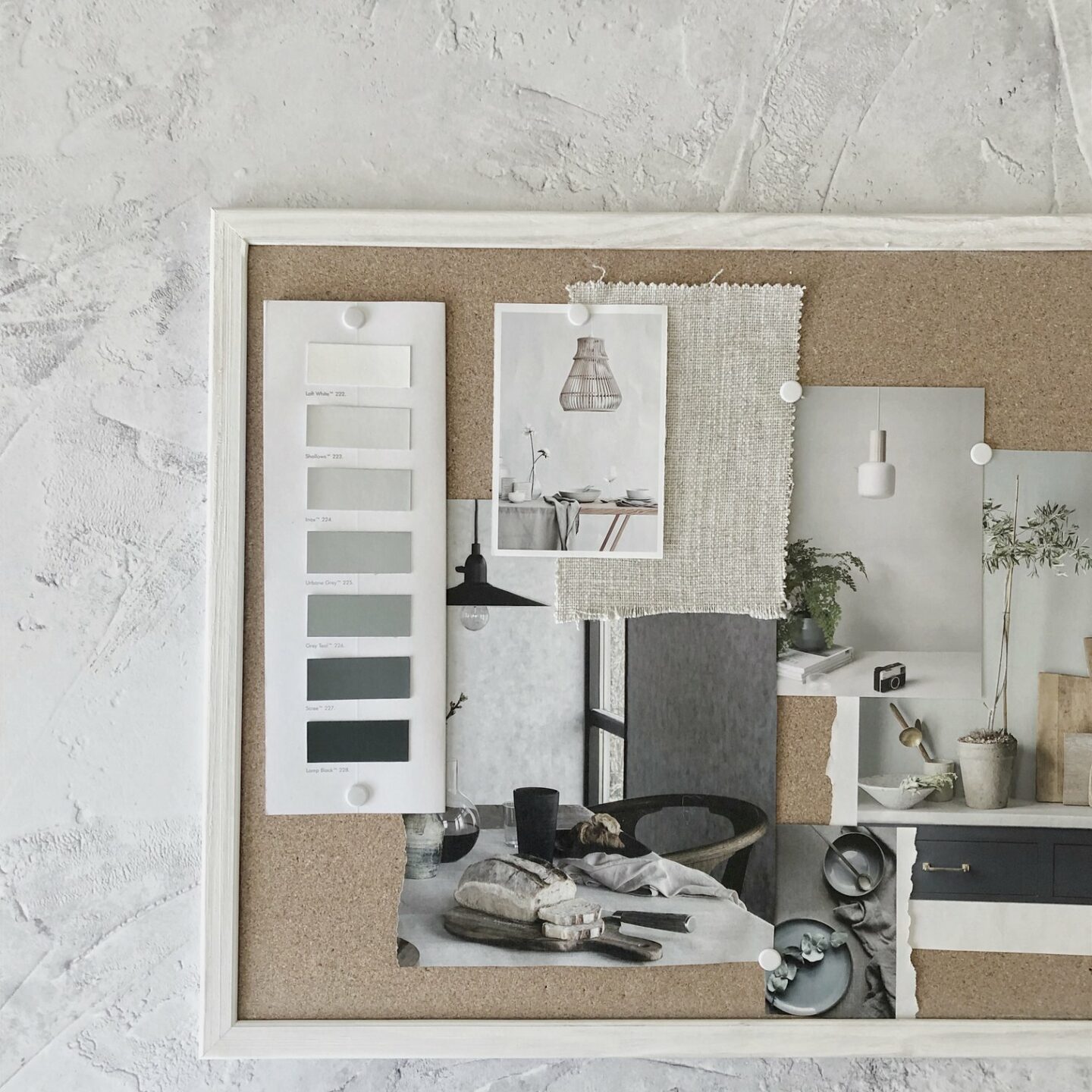 Grey slow living interiors mood board arranged on a cork board