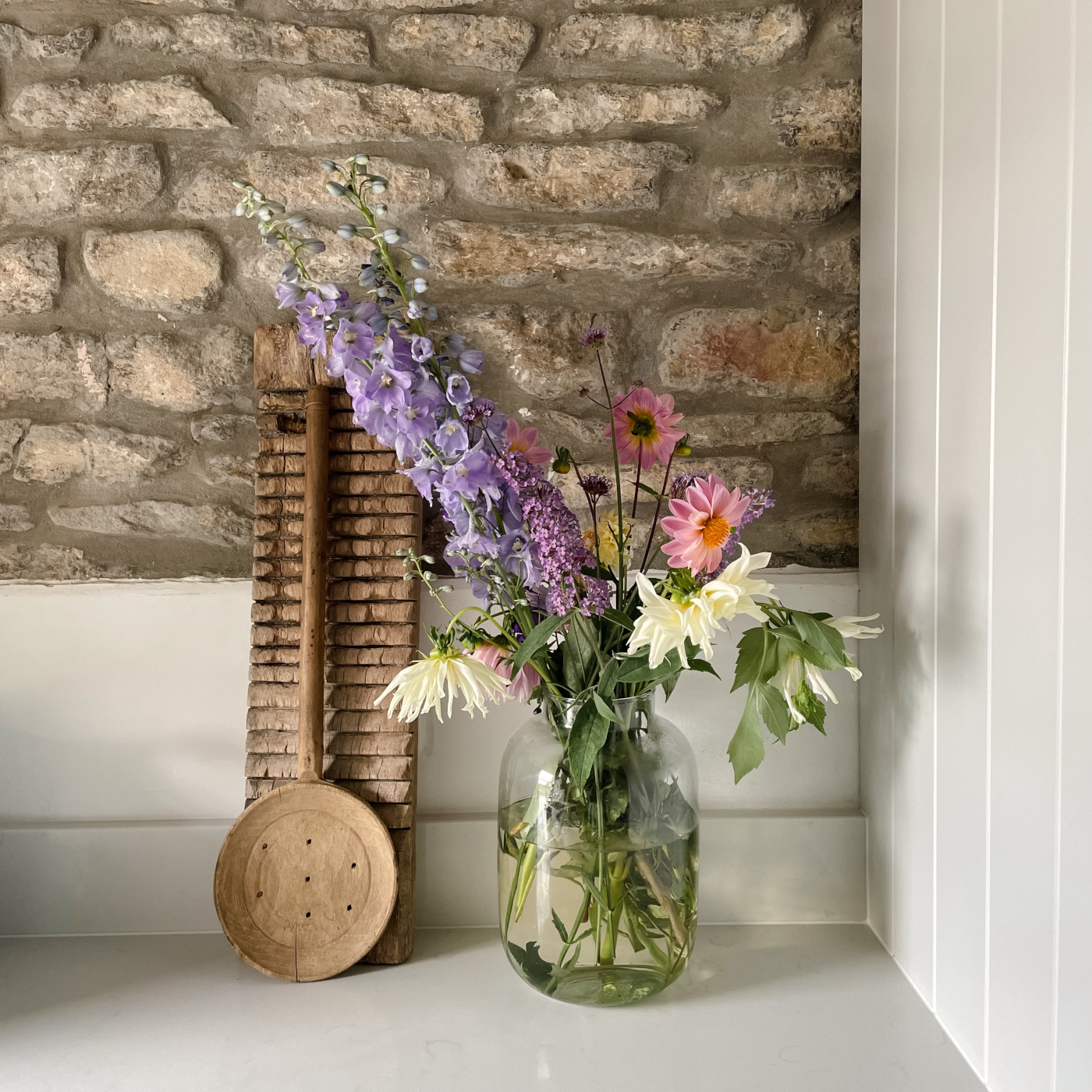 Vase cut flowers against stone wall