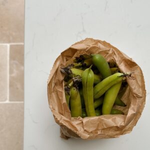 Paper bag of broad bean pods