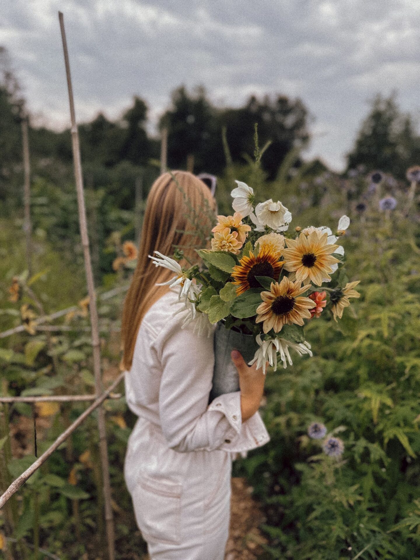 Girl holding late summer flowers in field